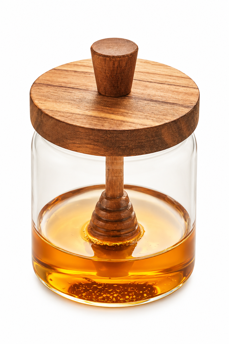 A honey pot filled with golden honey, featuring a round wooden lid with a wooden honey dipper resting inside.